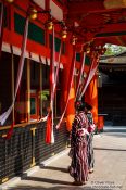Travel photography:Two girls in kimonos pray at Kyoto´s Inari shrine, Japan