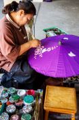 Travel photography:Woman painting a parasol at the Bo Sang parasol factory, Thailand