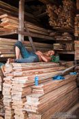 Travel photography:Man sleeping in a wood shop in Danang, Vietnam