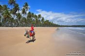 Travel photography:Boy riding a donkey on a Boipeba Island beach, Brazil