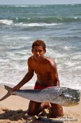 Travel photography:Boy with dorado fish on Boipeba Island, Brazil