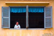 Travel photography:Girl looking out a window along a river near Battambang, Cambodia