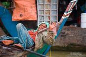 Travel photography:Man having a rest on his boat near Battambang, Cambodia