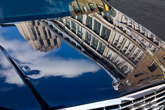 Montreal city buildings reflected on a car hood 