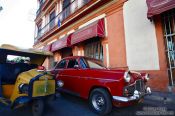 Travel photography:Classic car with a coco-taxi outside the Cigar Museum, Cuba