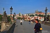 Travel photography:Tourists on the Charles Bridge with the Prague castle in the background, Czech Republic