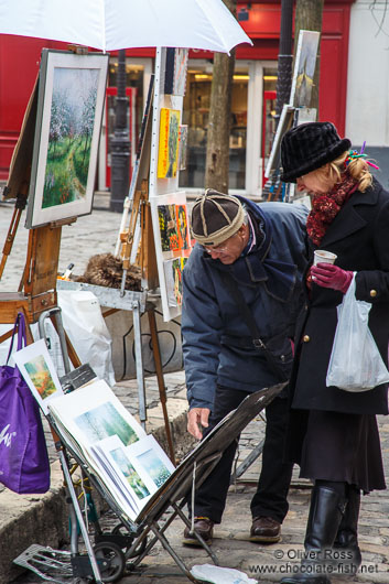 Passers-by browse through the art on offer in Paris´ Montmartre district
