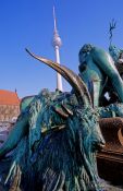 Travel photography:Neptunbrunnen (Neptune`s fountain) on Berlin`s Alexanderplatz with St.-Marien Kirche and Fernsehturm in the background, Germany