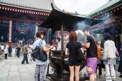 Travel photography:Visitors in Tokyo´s Senso-ji temple in Asakusa rub in smoke for good luck, Japan