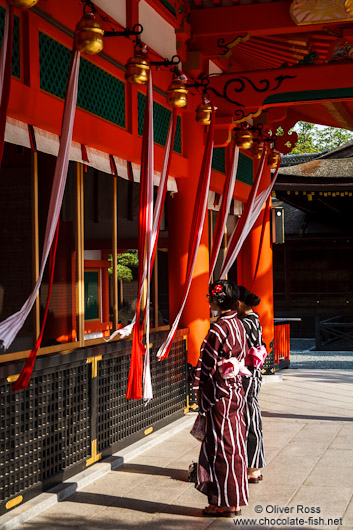 Two girls in kimonos pray at Kyoto´s Inari shrine