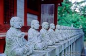 Travel photography:Row of little buddhas outside a forest shrine, Japan