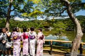 Travel photography:Girls in kimonos at the Golden Pavilion in Kyoto´s Kinkakuji temple, Japan