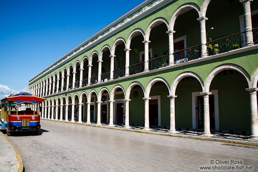 Colonnades along the main square in Campeche with tourist bus
