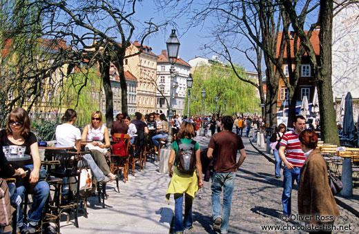Street cafes with people along the river in Ljubljana