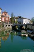 Travel photography:The Ljubljanica river in Ljubljana with the Franciscan church and Tromostovje (triple bridges) in the background, Slovenia