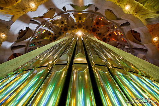 Colourful light from the stained glass windows is reflected off the organ pipes in the Sagrada Familia
