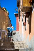 Travel photography:Toledo woman hanging clothes in street, Spain