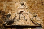 Travel photography:Facade detail above the entrance to the church in Pals, Spain