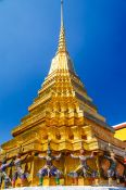 Travel photography:Demons supporting the giant golden stupa at Wat Phra Kaew, the Bangkok Royal Palace, Thailand