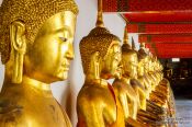 Travel photography:Row of golden Buddhas at Wat Pho temple in Bangkok, Thailand