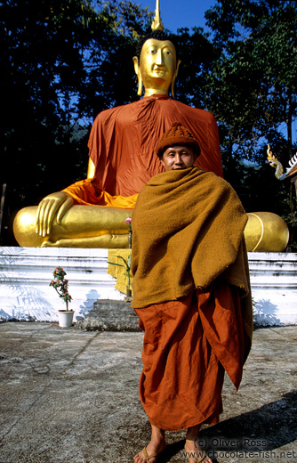 Monk with giant Buddha near Chiang Rai