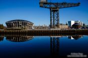 Travel photography:Glasgow River Clyde with disused dock crane and stadium, United Kingdom