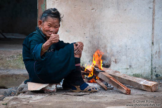 Hmong woman with small fire in a Sapa back yard