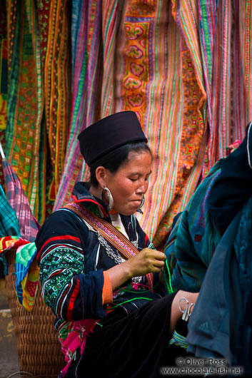 Hmong woman in front of her handy work in Sapa