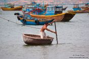 Travel photography:Man in a typical round boat in Mui Ne , Vietnam